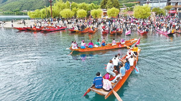 　　在泸沽湖景区，川滇群众参加摩梭传统猪槽船大赛。