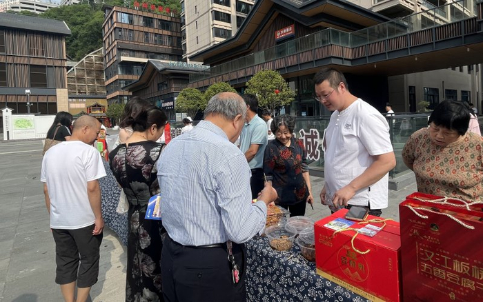 游客选购郧西本地农特产品“板桥豆干”。王洁洁摄