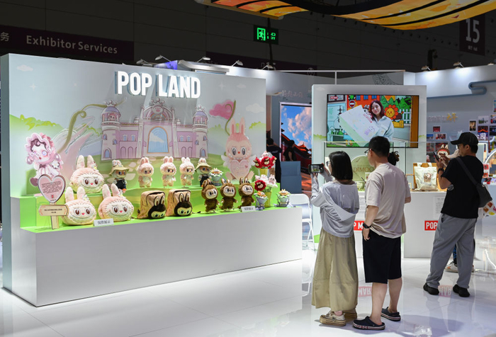 5月24日，在文博会北京展区，观众在泡泡玛特城市乐园展台前拍照。新华社记者 肖恩楠 摄
