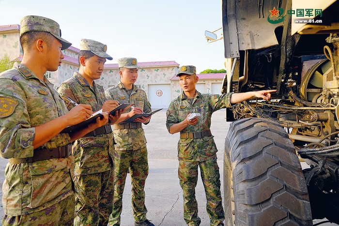 　　三级军士长朱启源（右一）组织团队骨干现场教学。秦志刚摄
