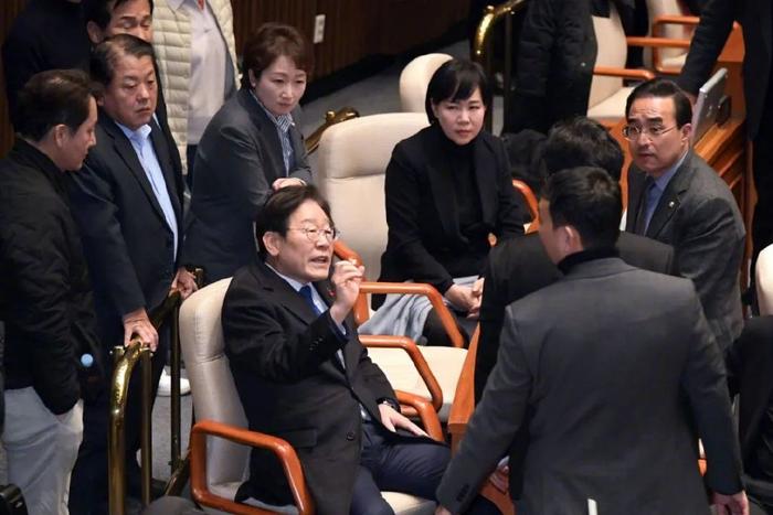 2024年12月4日,身处韩国国会内的李在明(中)。当日凌晨,韩国国会举行紧急全体会议,就“要求解除紧急戒严令”进行了投票。图/澎湃影像