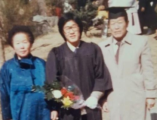 △李在明在大学毕业典礼上与父母合照。（图源：韩国《中央日报》）