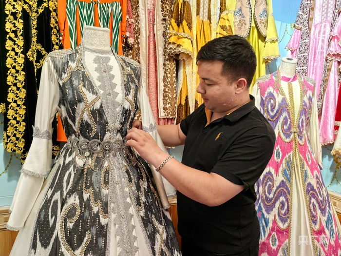 店主整理拍照服装  （央广网记者丁安  摄）