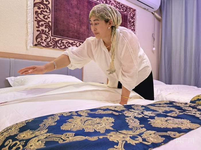 马健梅正在整理房间  （央广网记者丁安  摄）