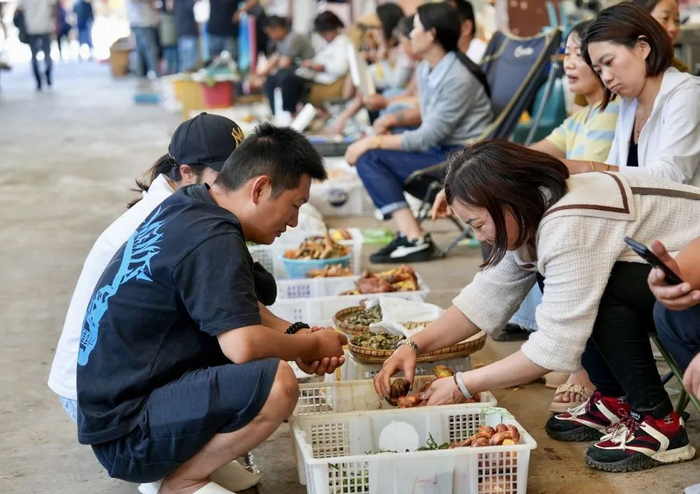 2025年6月5日，顾客在云南木水花野生菌交易市场内选购菌子。（徐俊 摄）