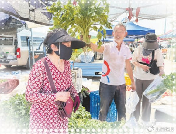 卖菜的大爷拿起一把芹菜向顾客推销