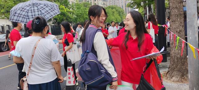 晋元高级中学考点外，宜川中学送考教师身着红色雨披，为入场考生加油打气，送上祝福 学校供图