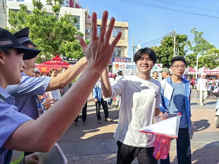 6月7日,海南省临高县临高中学考点外工作人员为考生加油。新华社记者夏天 摄