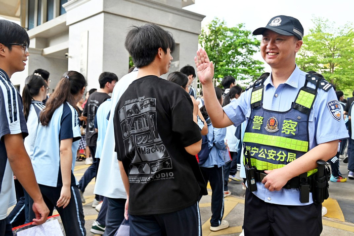     执勤民警与考生击掌为他们加油。 本报通讯员邓妍 摄