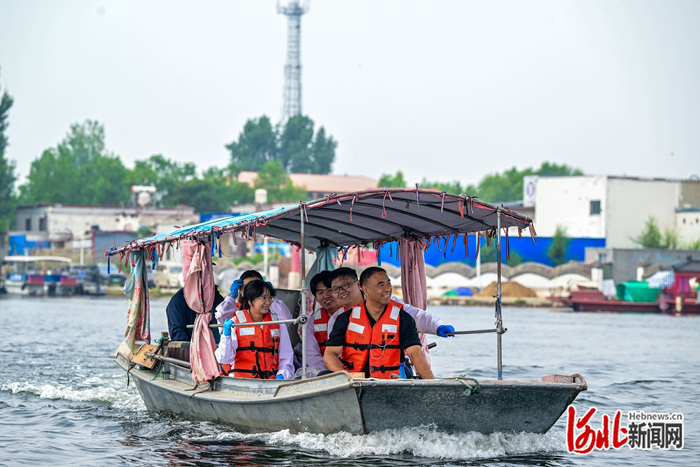 5月29日，王洪杰（右一）和科研团队乘船前往白洋淀近自然湿地修复实验区。