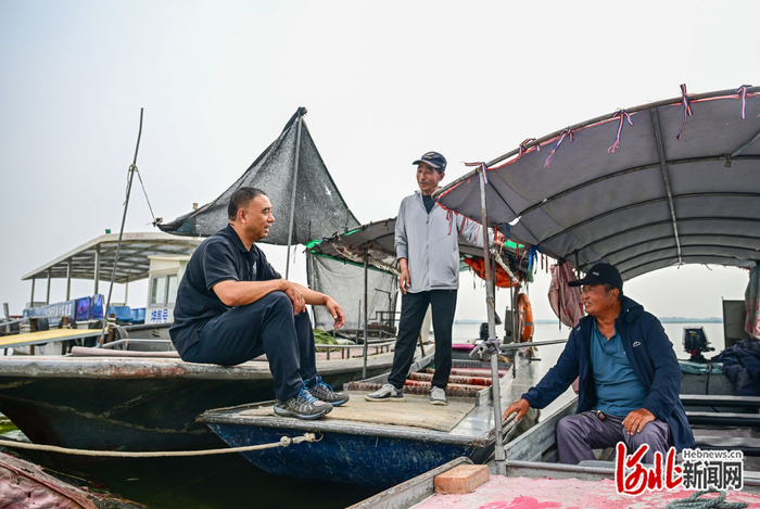 5月30日，王洪杰（左一）和村民聊家常。