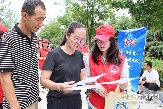 图为山西省临汾市气象“红马甲”向过往考生及家长发放气象服务材料。王建敏 摄影