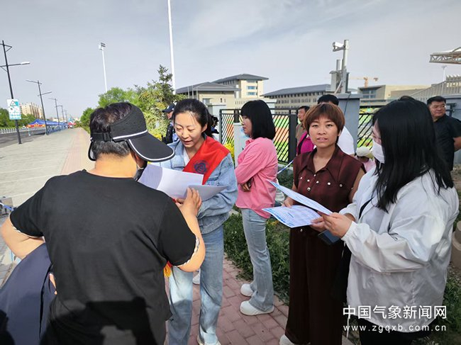 图为工作人员在考场外发放气象服务材料 宁香谢玉 摄影