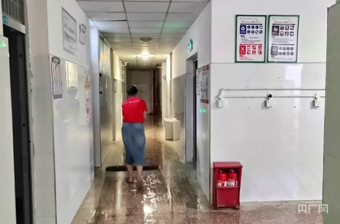 湖南师大附中博才实验学校（湘江校区）考点工作人员清理走廊积水（央广网发  湘江新区融媒体中心  供图）