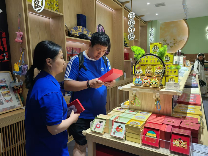 在太学有礼国子监文创空间，工作人员为游客介绍文创产品