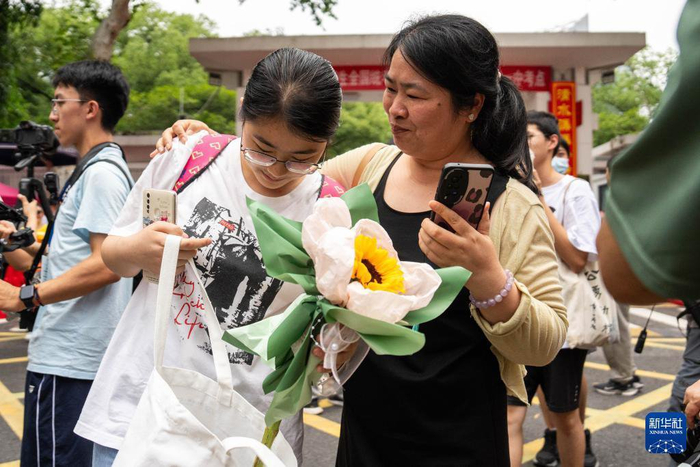 6月9日，在长沙市第一中学考点，一名家长（右一）迎接考生走出考场。当日，全国部分地区高考结束。新华社记者 陈思汗 摄