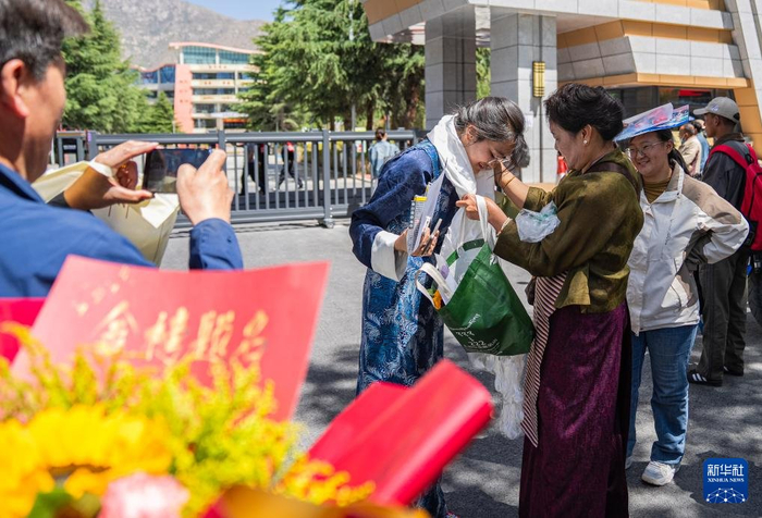 6月9日，在拉萨市拉萨中学考点门口，家长为结束考试的考生献哈达。当日，全国部分地区高考结束。新华社记者 丁增尼达 摄