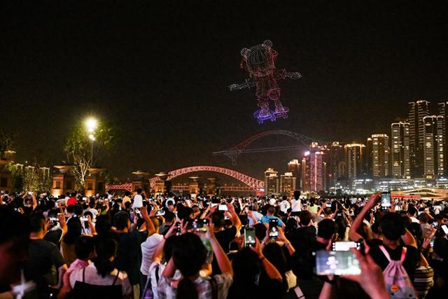 5月2日晚，游客在重庆朝天门广场观看无人机灯光秀。新华社记者 王全超 摄