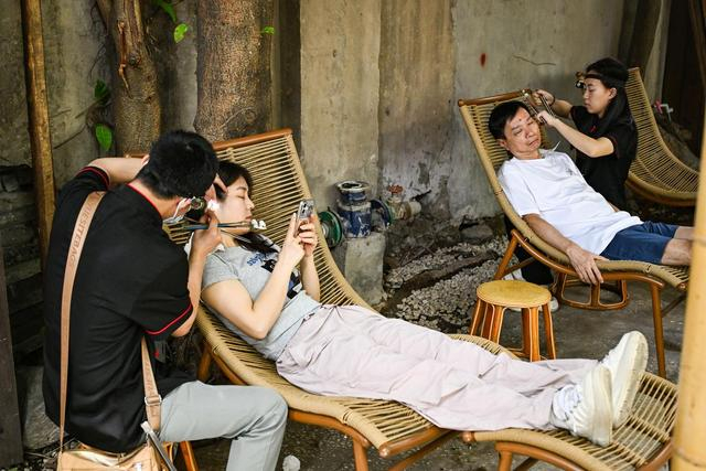 6月8日，游客在重庆市渝中区山城巷体验采耳服务。新华社记者 王全超 摄