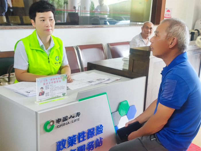 图：工作人员为村民提供政策性保险咨询服务