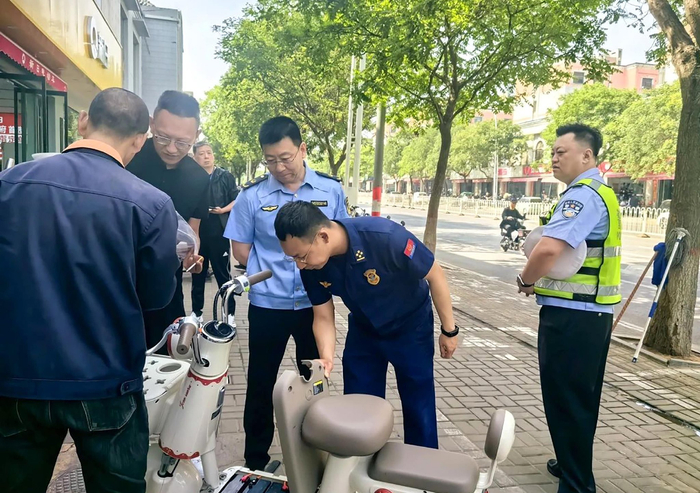 执法人员对电动自行车进行检查。晋中市市场监管局供图