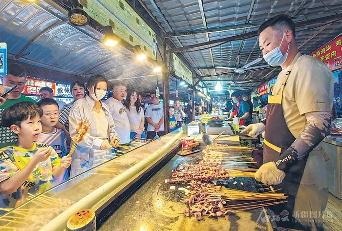 6月9日，顾客在位于哈密市伊州区的天街夜市小吃街选购美食。天山网-新疆日报记者蔡增乐 摄