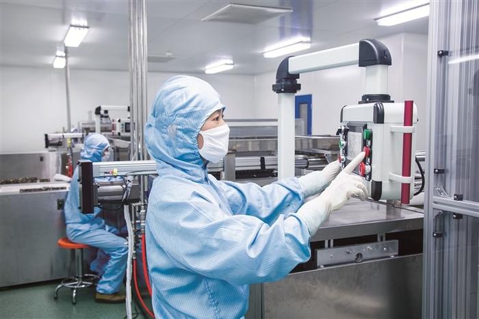 图为东阿阿胶工厂阿胶糕车间里,工人正在调节切胶机参数。