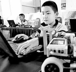     甘肃省张掖市甘州区大成学校体育馆内，参加张掖市第一届青少年人工智能和机器人竞赛的选手们在比赛。王将摄/光明图片