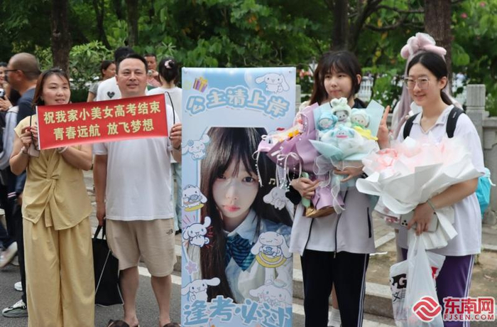 唐先生一家精心制作了一个易拉宝迎接女儿走出考场。