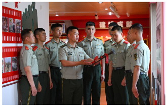 图为武警合肥支队执勤一大队执勤一中队中队长骆凡（左四）向战友分享老军号的战斗故事。本报通讯员 徐伟 摄