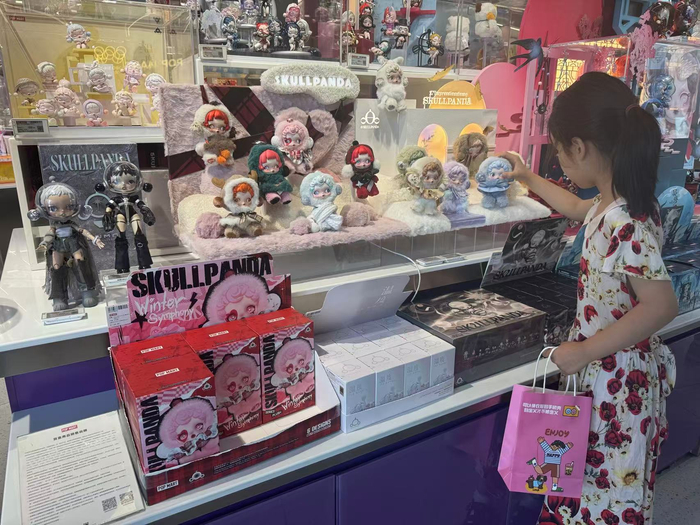 图片：顾客在体验泡泡玛特的SKULLPANDA搪胶毛绒玩具