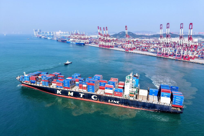 　　5月19日，山东港口青岛港，装载外贸集装箱的货轮驶出港口（无人机照片）。新华社发（俞方平 摄）