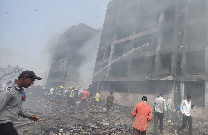 6月12日，在印度古吉拉特邦艾哈迈达巴德，人们在客机失事现场进行救援。图片来源：新华社/印度联合新闻社