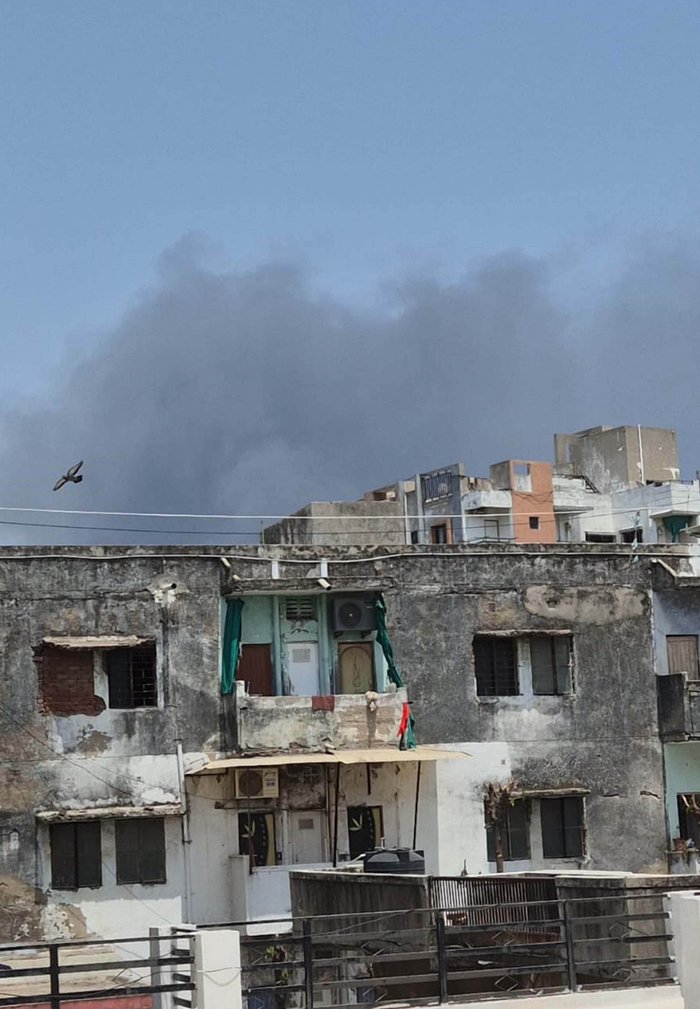 6月12日，在印度古吉拉特邦艾哈迈达巴德，客机失事现场冒起浓烟。图片来源：新华社/印度联合新闻社