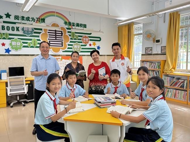 　　李锦记中国企业事务总监赖洁珊（后右一）、广州市从帅商贸有限公司总经理杜福林（后左一）了解学生们的阅读情况