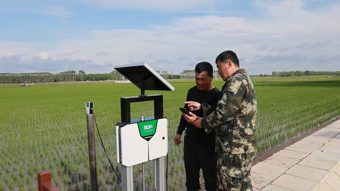 农业技术人员指导种植户应用智能水利灌溉系统（央广网记者李雪摄）