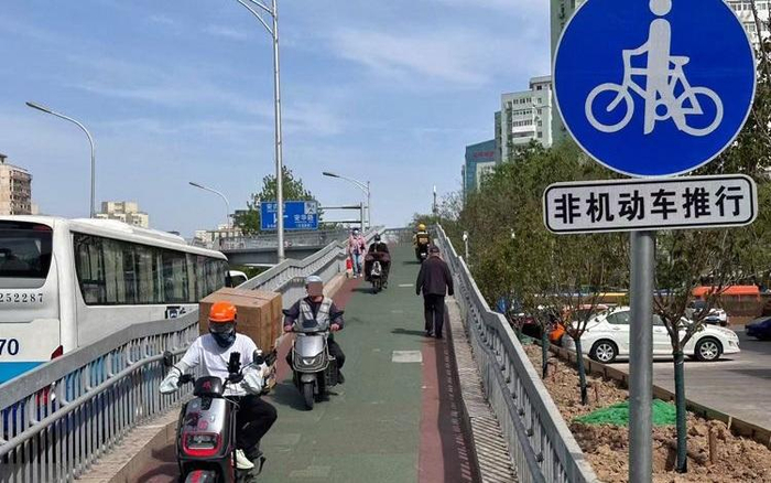 ▲资料图：北三环中路，多辆电动自行车扎堆儿在坡道上行驶。图/新京报记者王贵彬 