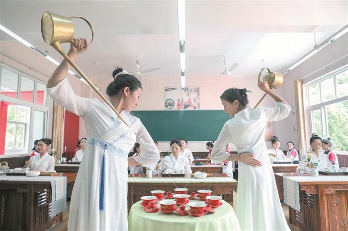 近日，两名学生在峨边职中教室里练习茶艺。图片来源：视觉中国