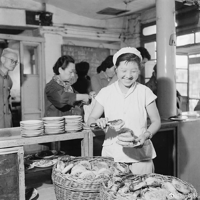 上世纪五六十年代，永顺居饭馆服务员给买早点的顾客夹火烧。高宏摄​