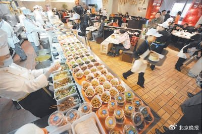 2010年，眉州小吃店内，统一佩戴帽子和口罩的厨师们制作着各种早点，大厅内的座位早已坐满。 饶强摄