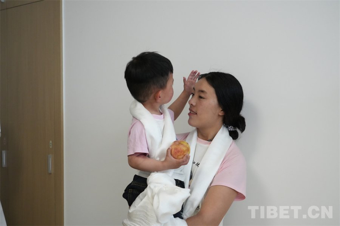 图为小卓玛轻抚妈妈强措的头，仿佛在让她放心 摄影：王茜