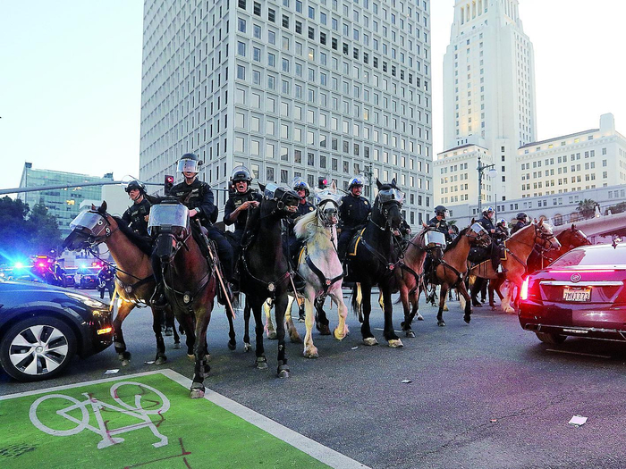     6月10日，在美国加利福尼亚州洛杉矶市中心，骑警在宵禁生效后试图驱散街上的人群。