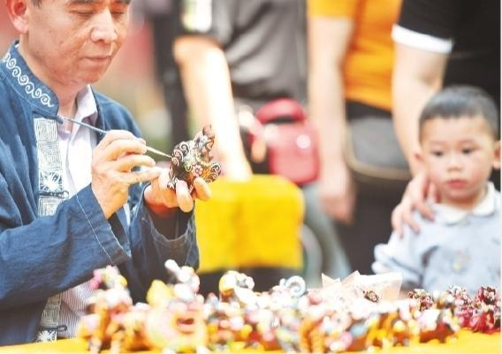 民间艺人在黄平县飞云崖景区展示传统泥哨技艺。宁坚 摄