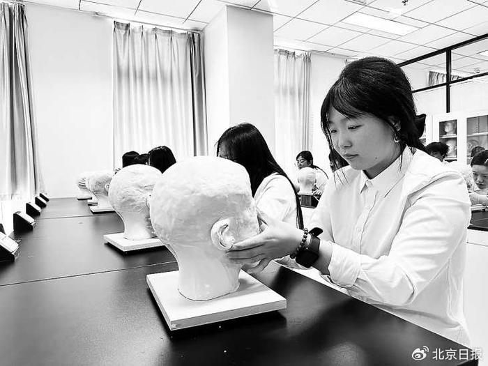 殡葬专业的学生正在上遗体防腐整容课程。