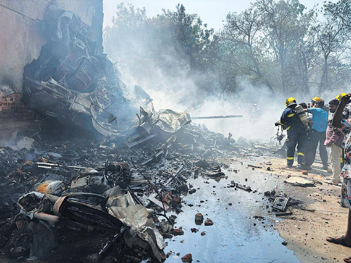 6月12日，消防员在印度古吉拉特邦艾哈迈达巴德附近坠机现场灭火。新华社/美联