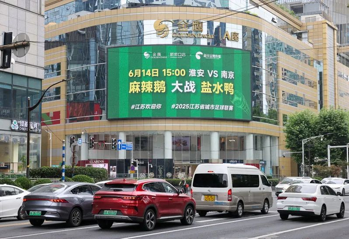 6月10日，新街口某商场大屏在播放2025江苏省城市足球联赛预热宣传片。