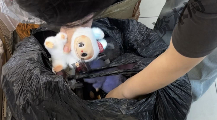 图说：商家从黑色塑料袋掏出仿制LABUBU