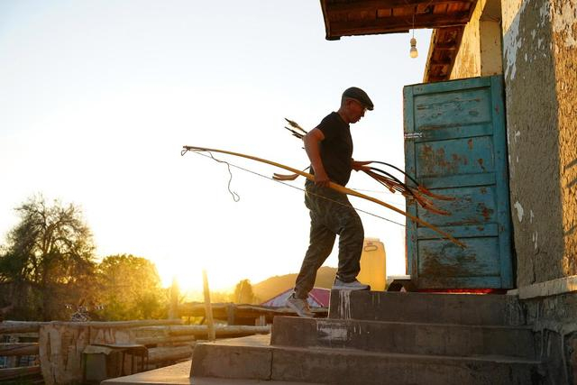 5月22日，在新疆阿勒泰市汗德尕特蒙古族乡汗德尕特村，铁木尔加甫将制作好的弓箭搬回屋中。新华社记者 徐宏岩 摄