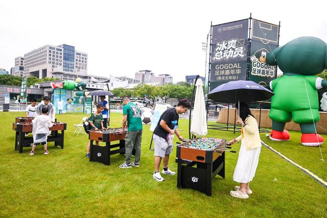 6月14日，在浙江俱乐部绿城队对阵上海海港队的比赛前，球迷在浙江俱乐部足球嘉年华活动现场体验桌上足球。新华社记者 江汉 摄
