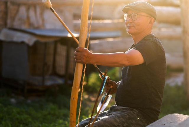 铁木尔加甫观察试用刚做好的弓箭（5月22日摄）。新华社记者 王菲 摄